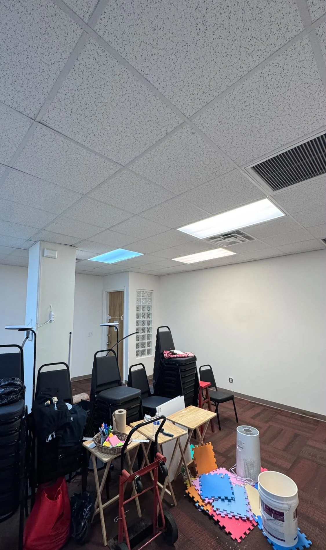 Large open commercial meeting room with clean white walls and a white support column
